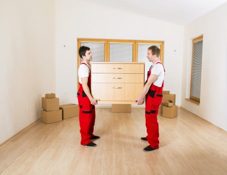 Crew loading furniture into a van at a narrow Highbury flat entrance